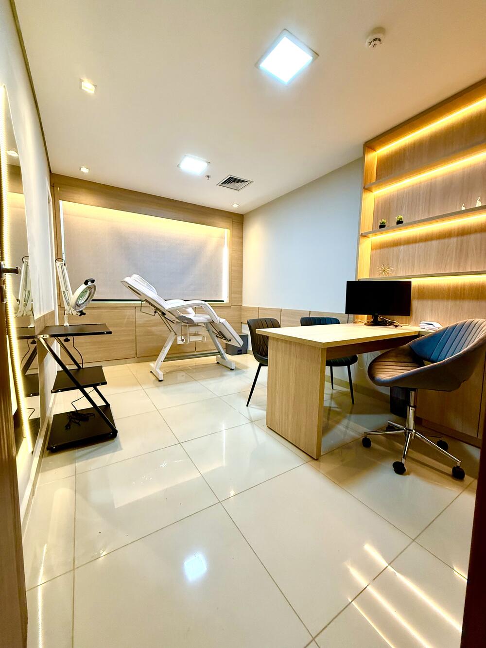 Sala 26 com maca da Smart Rooms no Trio Office Ribeirão, localizada no 16º andar, com banheiro privativo, ring light, monitor, ar-condicionado e estrutura premium para atendimentos profissionais em Ribeirão Preto.